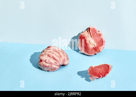 Composition of fresh fruits, juicy grapefruit cutted into slices on two-color background Stock Photo