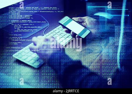 Working his way into your database. an unidentifiable computer hacker using a computer in the dark. Stock Photo