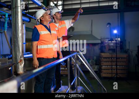 Mature engineers working in engineering factory Stock Photo