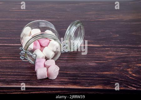 Marshmallows in a glass jar on a wooden background Stock Photo