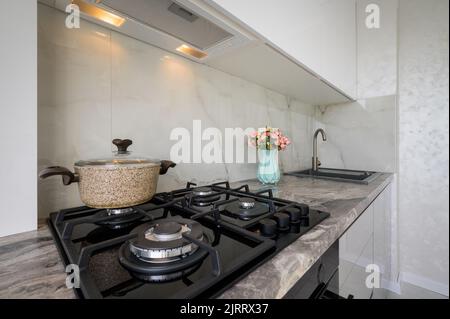 Gas stove and worktop closeup at white modern domestic kitchen Stock Photo