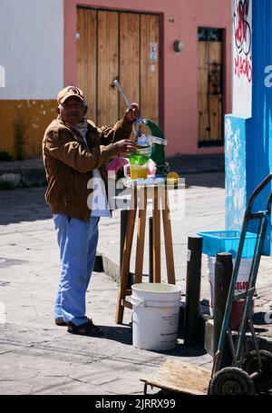 A closeup of a vendor making orange juice on the street in San Cristobal Stock Photo