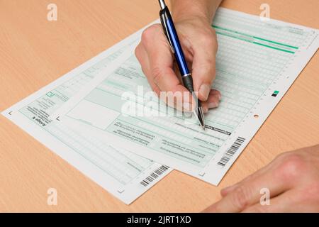 Close-Up of man's hand fill out a tax declaration or tax return with ...
