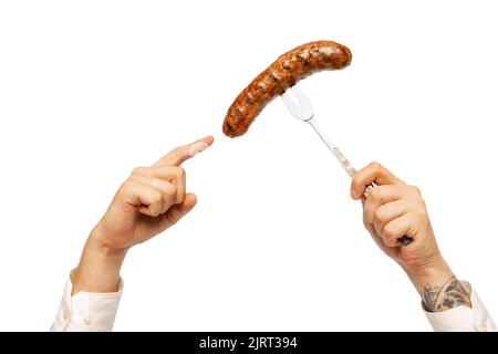 Male hands with grilled sausage on fork isolated over white studio background. German and Bavarian holidays Stock Photo
