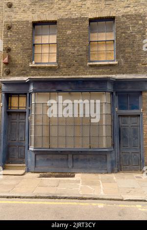Close up old abandoned house facade weathered blue store barred windows two entrance doors concept of loneliness abandonment decay Stock Photo