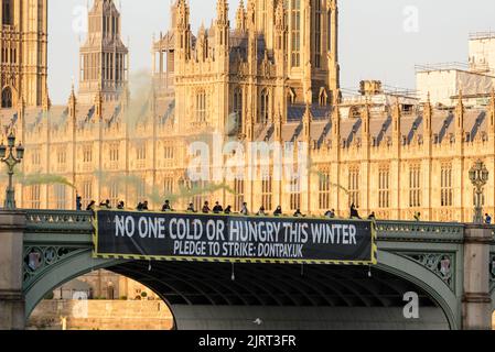 London, UK. 26th Aug, 2022. Don't Pay activists dropped a banner reading 'No one cold or hungry this winter' from Westminster Bridge in protest to the new energy price cap being announced by Ofgem at the same time. Credit: Andrea Domeniconi/Alamy Live News Stock Photo