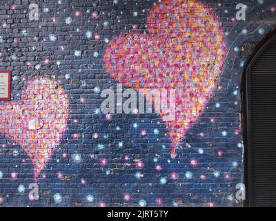 Pink Heart on Painted Brick Wall Stock Photo