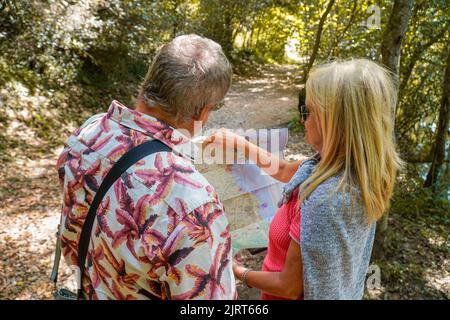 lost couple looking at a map in nature Stock Photo
