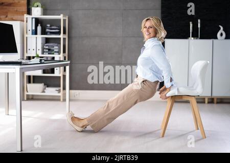 Chair Triceps Dip In Office. Workout Exercise At Desk Stock Photo