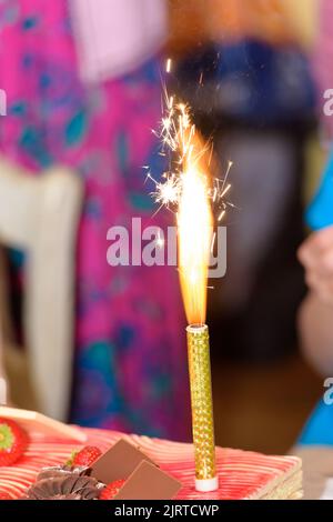 closeup of a fountain firework burning on a cake with a blurred background Stock Photo