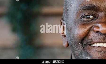 Close up joyful male human unshaved half face in details portrait mature african middle aged man healthy grandpa ethnic friendly grandfather pensioner Stock Photo