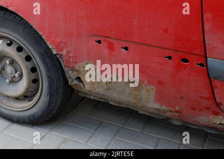 Corroded vehicle, damaged car body. Close-up photo of element rusty car. Stock Photo