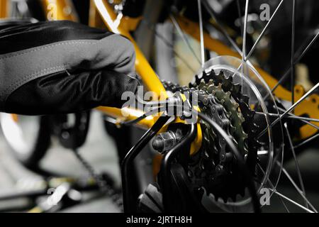 bicycle maintenance and repair. mechanic working in bike service workshop. gear closeup Stock Photo