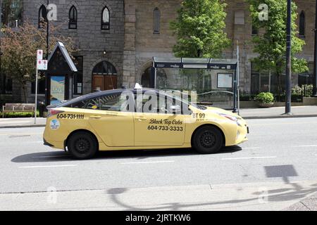 A yellow taxi car in the streets of downtown Vancouver, British Columbia, Canada Stock Photo