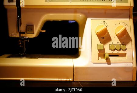 Sewing machine on table in tailor's workshop Stock Photo