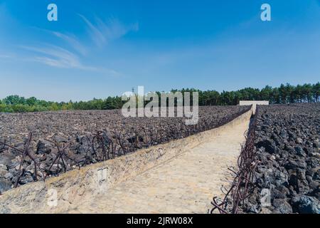 08.27.2022 - Belzec, Poland - Belzec Nazi Death Camp. Stone path in between walls of former nazi death camp with metal rods. Entrance to holocaust memorial museum. Horizontal shot. High quality photo Stock Photo