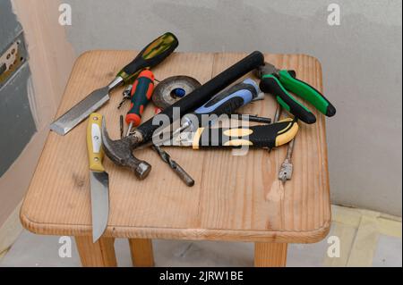 working tools lie in a chaotic order on the chair, repairs in the house, a variety of tools. Stock Photo