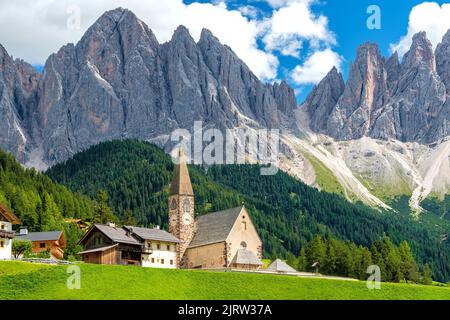 Small church Saint Magdalena in Villnöß (Funes) in South Tyrol in northern Italy with the Gruppo delle Odle mountains of the Dolomite Alps in the back Stock Photo