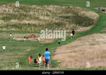 London, UK. 26th Aug, 2022. Children run down Parliament hill on the revived grass - Rain after the Hot weather results in a green and yellow landscape on Hampstead Heath. Credit: Guy Bell/Alamy Live News Stock Photo