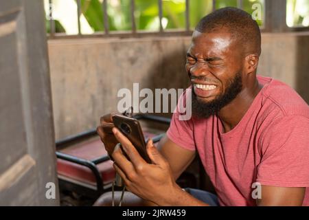 generator repair man feeling excited holding his phone Stock Photo