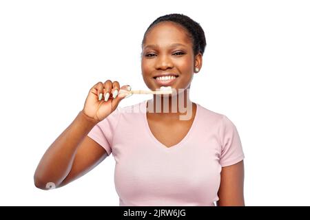 smiling woman with toothpaste on wooden toothbrush Stock Photo