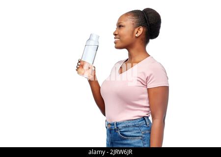 happy african woman drinks water from glass bottle Stock Photo