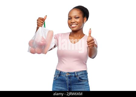 happy woman with vegetables in reusable net bag Stock Photo