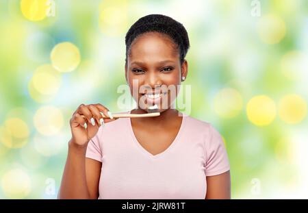 smiling woman with toothpaste on wooden toothbrush Stock Photo