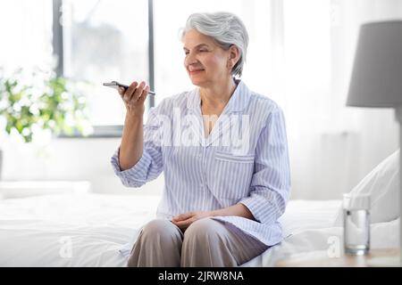 happy senior woman recording voice on smartphone Stock Photo