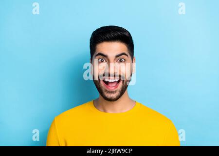 Photo of impressed funky guy dressed yellow pullover smiling open mouth isolated blue color background Stock Photo