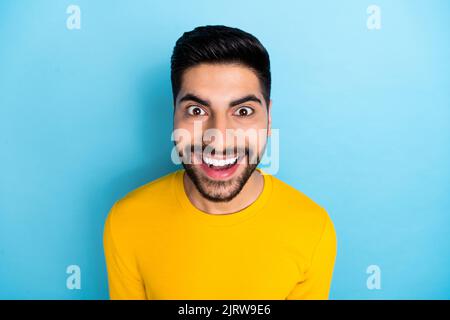 Photo of funky excited young indian guy dressed yellow pullover smiling isolated blue color background Stock Photo
