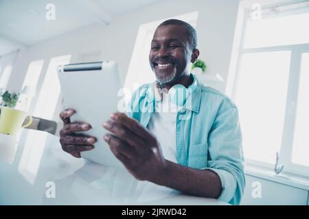 Portrait of cheerful nice person hold use tablet typing communicating coworking kitchen indoors Stock Photo