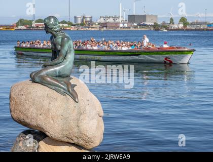 Tourists in Copenhagen Denmark visiting the bronze sculpture of the Little Mermaid by Edvard Eriksen on the Langelinie promenade by the city's harbour
