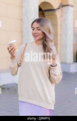 The girl is looking at craft paper cup of coffee. Stock Photo