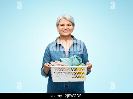 smiling senior woman with laundry basket Stock Photo