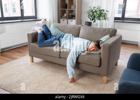 young man sleeping on sofa at home Stock Photo
