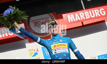 Marburg, Germany. 26th Aug, 2022. Cycling: Tour of Germany, Meiningen - Marburg (200.70 km), stage 2. Jakob Geßner from Germany of Team Lotto Kern Haus wears the blue jersey of the leader in the mountain classification at the award ceremony. Credit: Arne Dedert/dpa/Alamy Live News Stock Photo