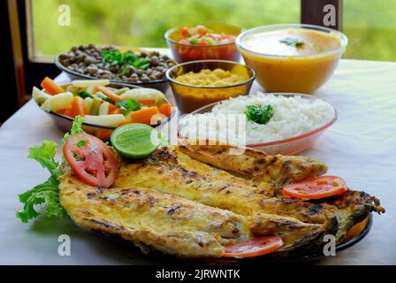 Tilapia fillet grilled at the table, served with beans, rice, farofa, mush and vinaigrette. Brazilian cuisine. Stock Photo