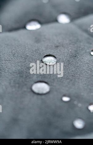 Closeup or macro of a small water drop on water repellent fabric or cloth Stock Photo