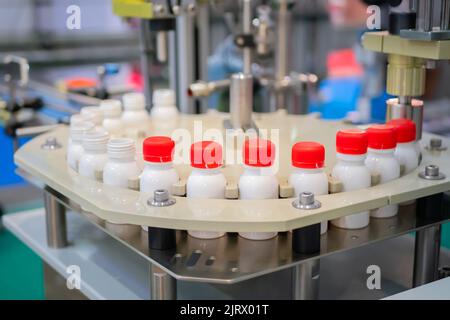 Row of white pet bottles with dairy product on conveyor belt - close up Stock Photo