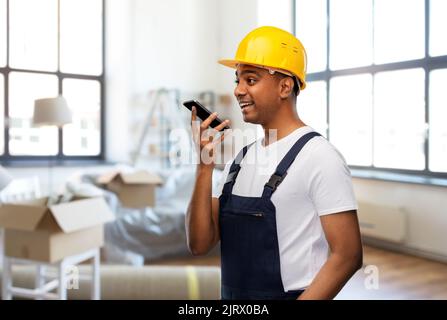 indian worker recording voice on phone at new home Stock Photo