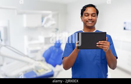 smiling doctor using tablet pc at dental office Stock Photo