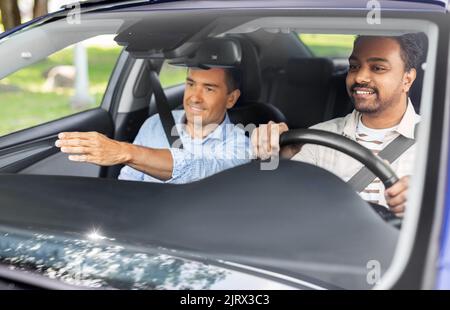 car driving school instructor teaching male driver Stock Photo