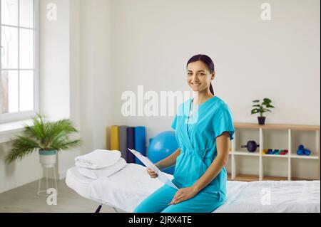 Smiling female doctor in uniform in hospital cabinet Stock Photo