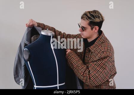 Fashion designer placing clothes on a mannequin. Designer working on a new clothing item. High quality photo Stock Photo