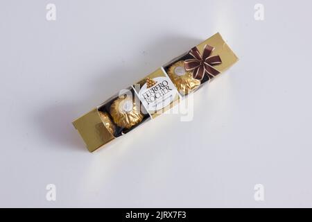 A closeup of a box chocolate of Ferrero Rocher on a white table Stock Photo