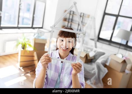 happy asian woman with ruler moving to new home Stock Photo