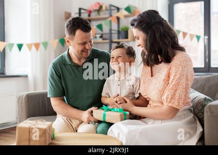 parents giving birthday present to little son Stock Photo