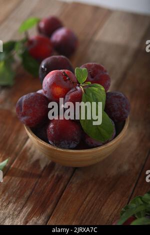 Fresh plum. Harvest. Autumn harvest. Blue plums. Plums on a wooden surface. Fresh plums on wooden table background. Stock Photo
