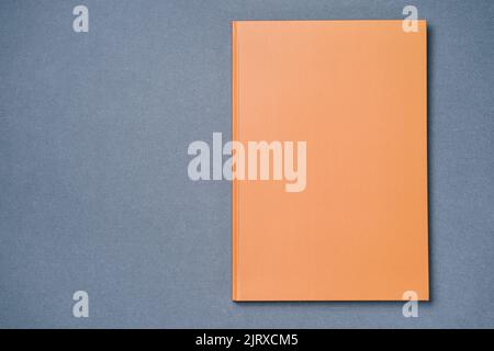 Orange Leather notebook on paper gray background, notepad mock up, top view shot Stock Photo